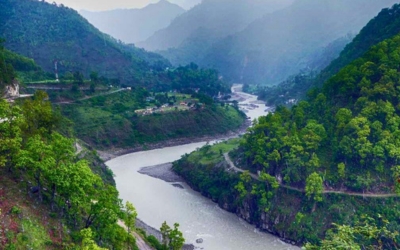 A river winding through a deep green valley and mountains